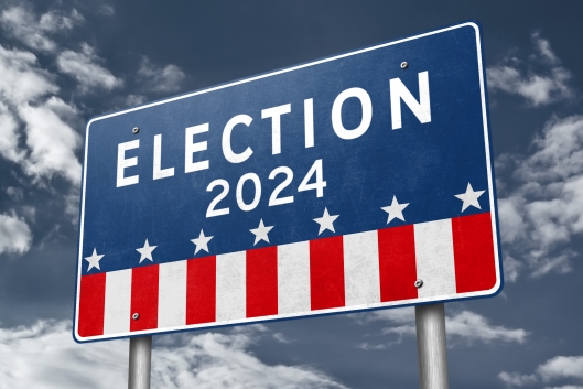 A red, white and blue highway billboard sign that says "Election 2024" above stars and stripes.