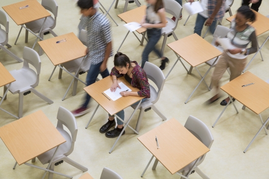 Elevated view of students writing their exam in classroom