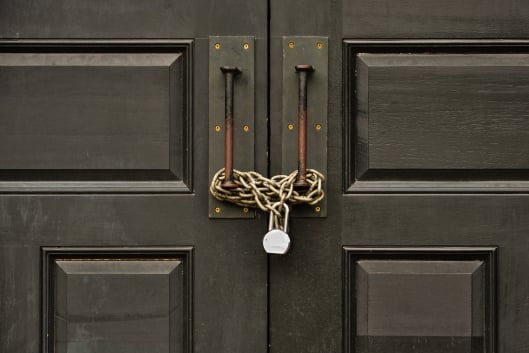 A photo of a door that is chained shut and locked.