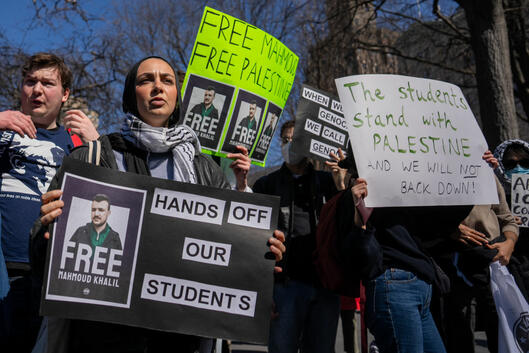Demonstrators hold signs with photos of Mahmoud Khalil that say "Free Mahmoud, free Palestine"