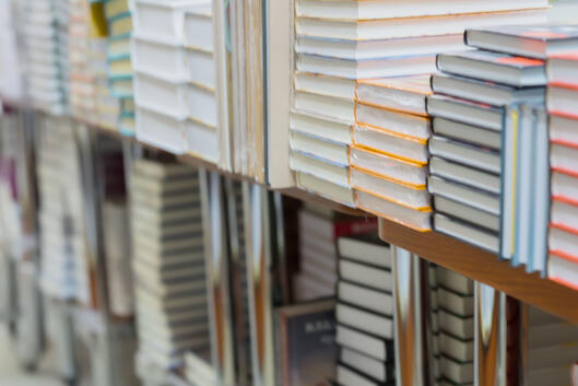 Stacks of books, textbooks or fiction in bookstore or in library