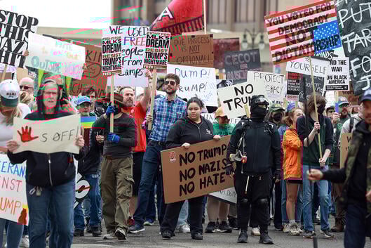 Protesters carry signs during a "Hands Off" protest rally in Detroit, Michigan.