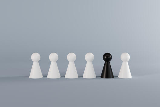 A row of six pawns (chess pieces) against a gray background. Five of the pawns are white and one pawn, placed second to the right, is black.