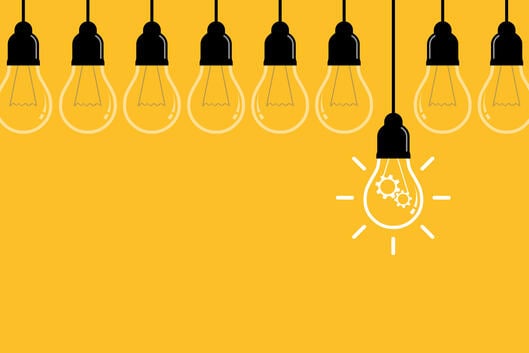 An illustration of a nine hanging lightbulbs against a yellow background; one bulb hangs lower and brighter than the other, suggesting a great idea or innovation.