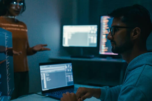Female programmer is giving an interactive training session, focusing on hands-on learning in digital classroom environment. Software developer, artificial intelligence and programming concept.
