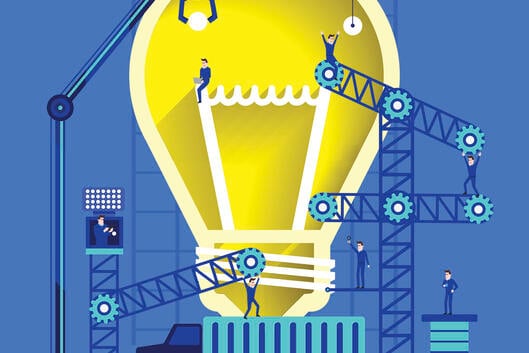 An illustration of a light bulb, signaling an idea, atop a truck, with construction scaffolding and people surrounding it. The illustration suggests idea building or the transfer of an idea to market.