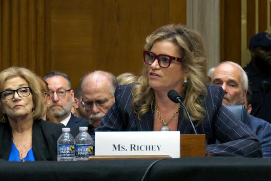 Kimberly Richey, a white woman with blond streaks in her hair, sits at a table in front of an audience during a confirmation hearing on Thursday.