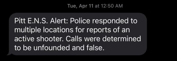 A text message, received on April 11 at 12:50 a.m., reading: "Pitt E.N.S. Alert: Police responded to multiple locations for reports of an active shooter. Calls were determined to be unfounded and false"