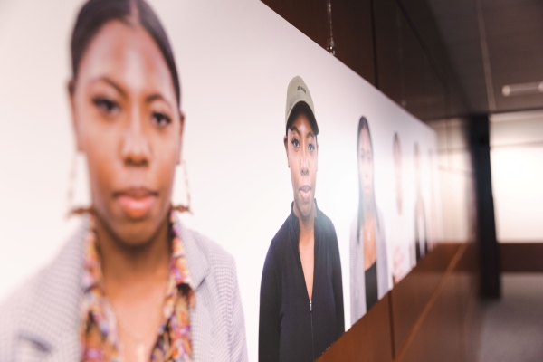 Portraits of people from various races on a white background in an art gallery.