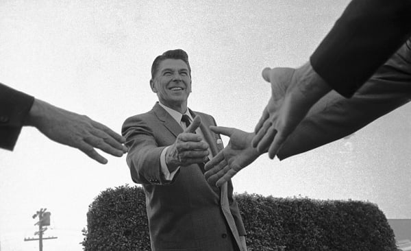 Ronald Reagan shaking hands in a black and white photo from the mid-1960s