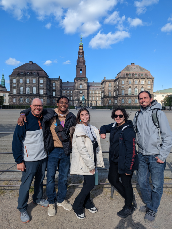 Five people stand in front of Denmark's Parliament in Copenhagen