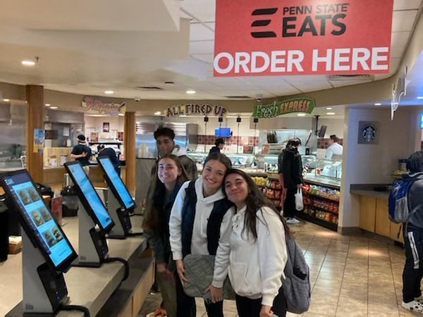 Penn State students in front of kiosks in the dining hall 