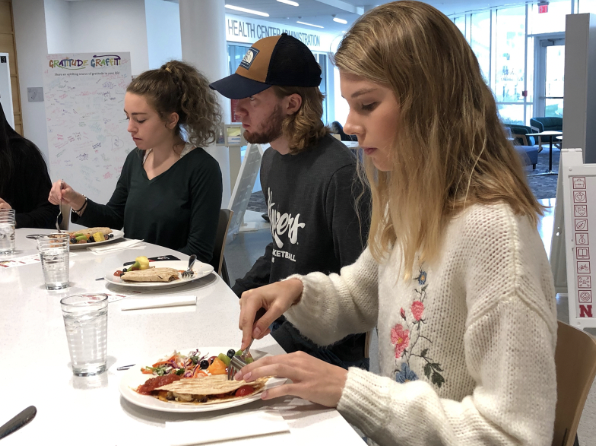 Three students eat a light meal at the University of Nebraska at Lincoln’s Kitchen Table demonstration kitchen.