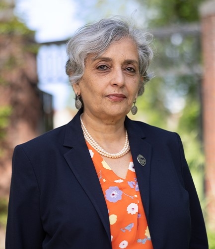Jayathi Murphy, an older woman with light brown skin and short gray-white hair wearing a blue blazer and a triple string of pearls.