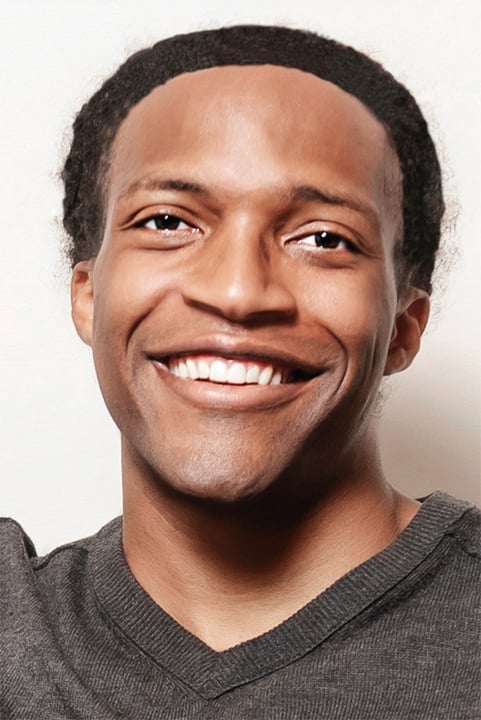 Head shot of a young dark-skinned male physician with dark hair wearing a gray V-neck