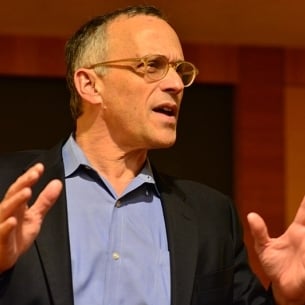 Michael Roth, a light-skinned man with short dark hair that is gray at the temples. He is wearing glasses and a blue collared shirt under a dark jacket.