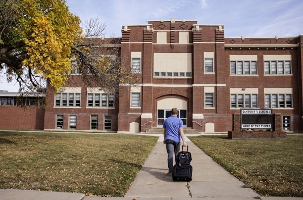 A WashU admissions representative approaches a rural high school 