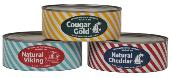 Three cans of Cougar Gold cheese stacked into a pyramid in striped packaging.