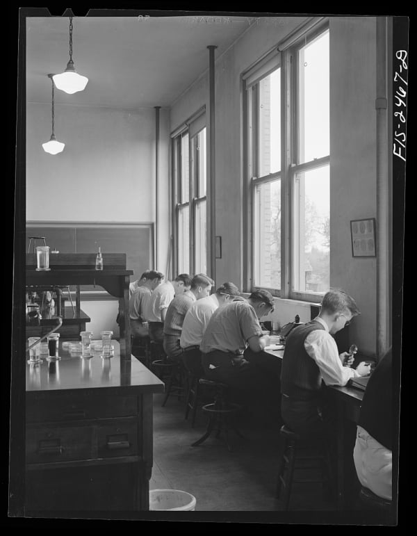 Students sit at a row of desks in a lab. 