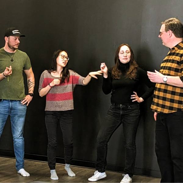 Four students play an improv game on stage