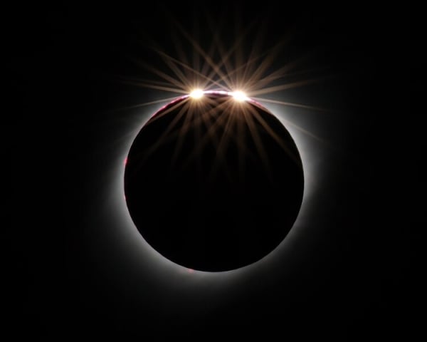 A circle of light that appears to have two light "beads" against a black background.