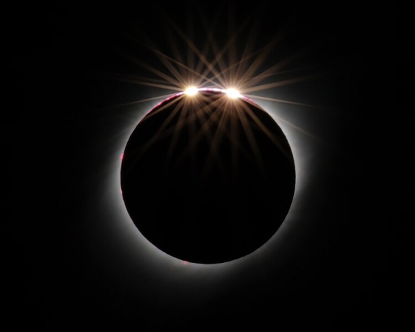 A circle of light that appears to have two light "beads" against a black background.