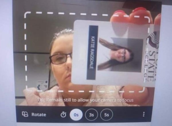 Woman showing her student ID to a computer camera