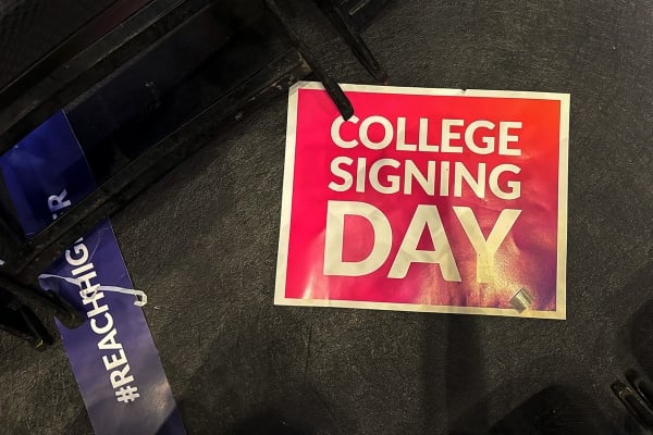 Two signs on the ground, saying College Signing Day