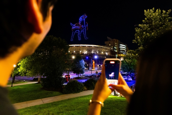 Two students watch a drone display at UT Knoxville's Tennessee Saturday Night event.