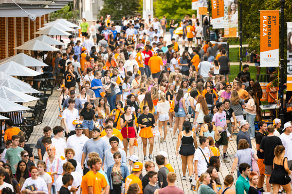 Students walk around campus during the University of Tennessee Knoxville's Tennessee Saturday Night Event wearing black and orange
