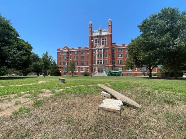 A photo of a stately campus building sitting on a patchy lawn.