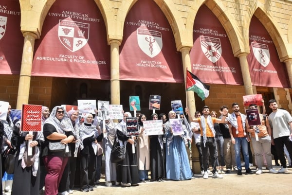 Student protesters, some wearing keffiyehs and carrying the flag of Palestine