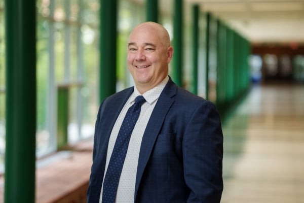 A headshot of Mike Gavin, president of Delta College, a light-skinned bald man wearing a blue suit.