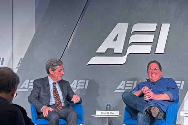 two men sit on stage