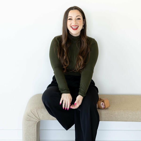 Katie Bogen, a light-skinned woman with long dark hair wearing bright red lipstick.