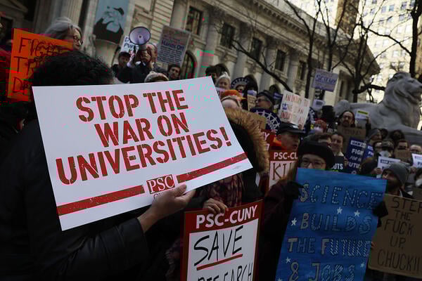 A white poster with red text that says stop the war on universities