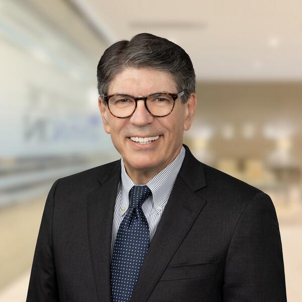 Jim Newberry, a light-skinned man wearing glasses and a business suit and tie
