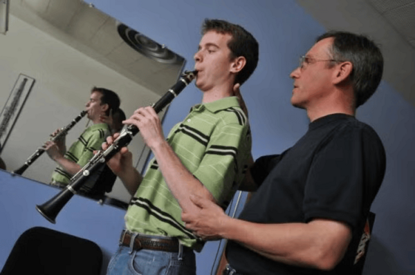 James Brody helps position a young clarinet player to improve his posture