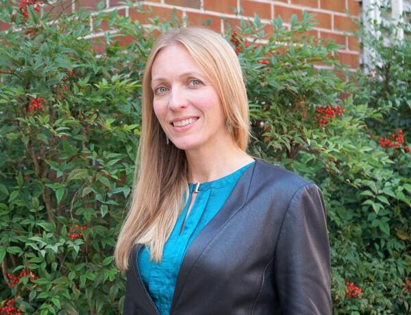 Headshot of Kimberly Terrell, a light-skinned woman with long blond hair wearing a teal blouse under a darker jacket.