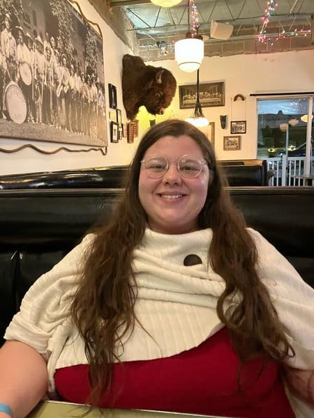 Kathryn Cook, a white woman with long brown hair and glasses.