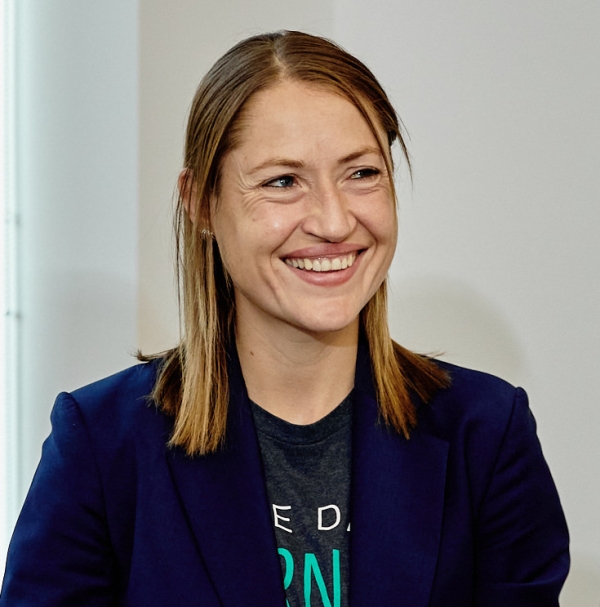 A light-skinned woman with straight light brown hair wearing a blazer over a T-shirt.