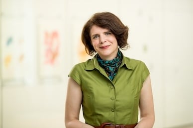 Mary Wright, a light-skinned woman with brown hair wearing a green top and a blue patterned scarf around her neck.