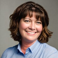 Rebecca Jenkins, a light-skinned woman with brown hair wearing a blue shirt.