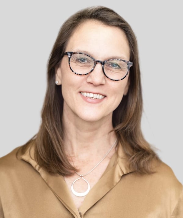 Stephanie Khurana, a light-skinned woman with shoulder-length brown hair wearing glasses.