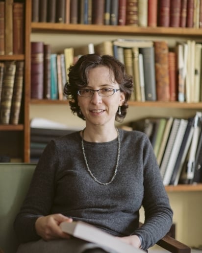 Julie Hruby, a light-skinned woman with short, wavy dark hair and oval-shaped glasses.