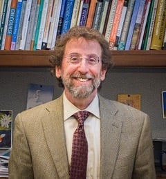 Matthew Kaplan, a light-skinned man with glasses and a beard.
