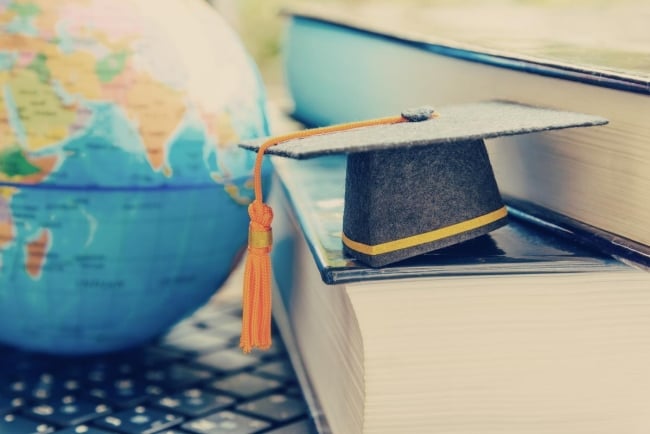 A mortarboard next to a globe.