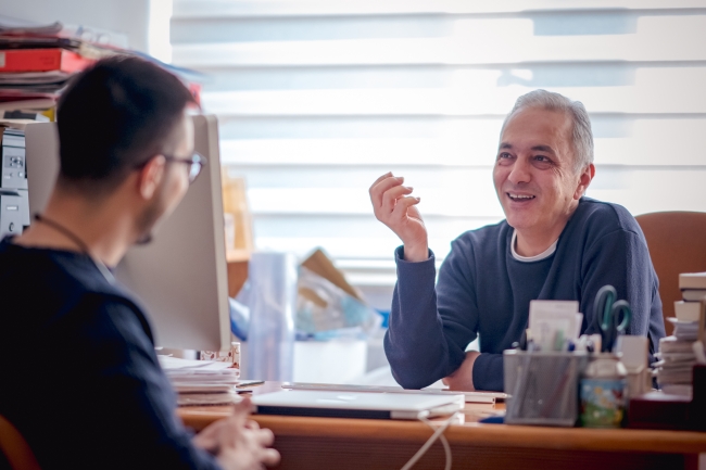 A professor meets with a student in his office.