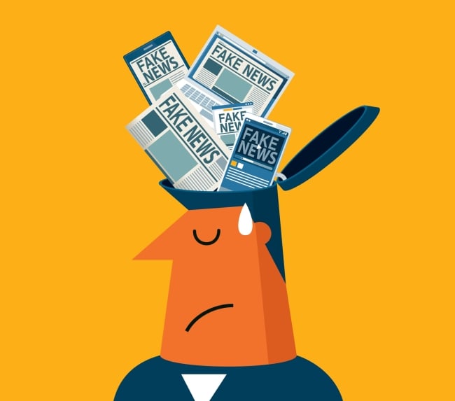 Cartoon image of a man with his eyes closed and a frown. The top of his head has an open lid into which newspapers with headlines declaring "fake news" are stuffed.