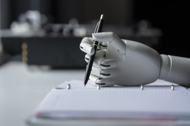 Artificial robotic arm writing down some notes with pen - stock photo